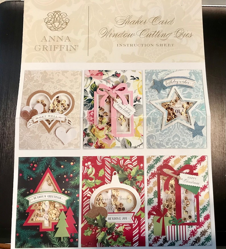 May include: A sheet of instructions for shaker card window cutting dies. The sheet shows six different shaker card designs with various themes, including birthday, get well, and Christmas. Each design features a window cut-out with a shaker element filled with sequins.