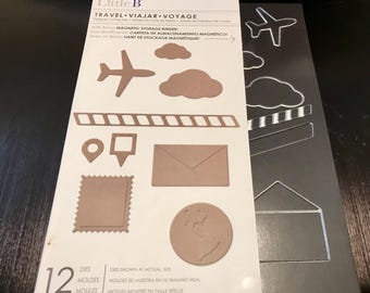 May include: A set of 12 metal dies for crafting, featuring travel-themed shapes like airplanes, clouds, envelopes, and a stamp. The dies are shown at actual size and come with a magnetic storage binder.
