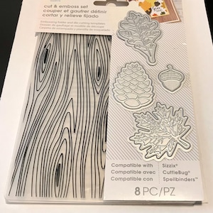 May include: Cut and emboss set with 8 pieces, including a woodgrain background, an acorn, a pine cone, and two leaf designs. Compatible with Sizzix, CuttleBug, and Spellbinders.