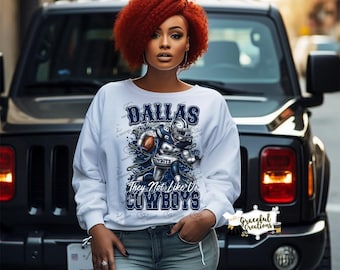 May include: White sweatshirt with a Dallas Cowboys graphic. The design features a football player in a helmet and the text "DALLAS They Not Like Us COWBOYS". The sweatshirt is worn by a person with red hair.