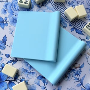 May include: A set of three ceramic mugs with a speckled, matte finish. The mugs are in shades of cream, light brown, and dark brown. Each mug has a simple, minimalist design, perfect for coffee or tea.