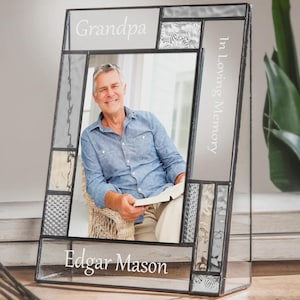 May include: A stained glass photo frame with the words "Grandpa", "In Loving Memory", and "Edgar Mason" etched in white. The frame holds a photo of a smiling man. The frame has a black border and decorative glass panels.