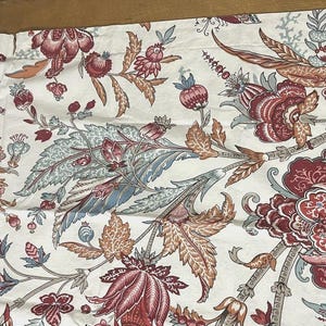 May include: A rectangular fabric pillowcase featuring a cream-colored background with a repeating botanical print. The pattern consists of large, stylized flowers, intricate leaves, and berries in shades of deep red, muted orange, and soft blue.