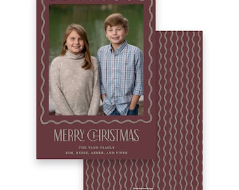 May include: A Christmas card with a photo of two children framed by a decorative border. The card features the text "MERRY CHRISTMAS" and the family's name. The back of the card has a repeating wavy pattern.
