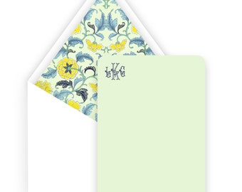 May include: A light green stationery card with a white envelope. The envelope liner features a floral pattern with blue and yellow flowers on a light green background. The card has the monogram "LKG" printed in blue on the top right corner.