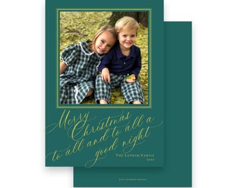 May include: A Christmas card with a photo of two children in a gold-framed image. The card is teal with gold script that reads "Merry Christmas to all and to all a good night." The family name and year are also printed on the card.