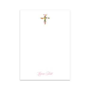 Puede incluir: Un bloc de notas blanco con un diseño de cruz floral en la parte superior y el nombre "Leanne Todd" escrito en cursiva rosa en la parte inferior.
