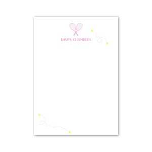 Puede incluir: Papelería blanca con temática de tenis. El diseño presenta dos raquetas de tenis rosas cruzadas sobre el texto "DAWN CHAMBERS" en rosa. Pelotas de tenis amarillas y líneas curvas acentúan el diseño.