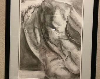 Könnte beinhalten: Eine Schwarzweiß-Kohlezeichnung einer nackten Figur in liegender Pose. Die Zeichnung ist in einem schwarzen Rahmen mit einem weißen Passepartout gerahmt.