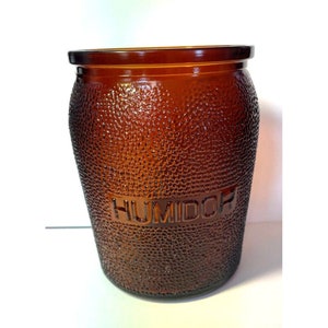 May include: A brown glass jar with a textured surface and the word "HUMIDOR" embossed on the front.