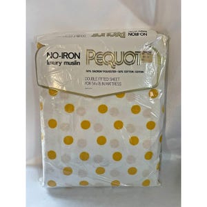 May include: A white fitted sheet with a yellow polka dot pattern. The sheet is packaged in plastic and has a label that reads "No-Iron Pequot luxury muslin 50% Dacron Polyester 50% Cotton/Coton Double Fitted Sheet for 54x76 in Mattress".