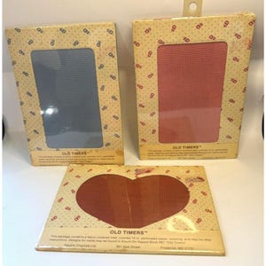 May include: Three vintage "Old Timers" needlepoint kits. Two kits have rectangular openings with blue and pink mesh. The third kit has a heart-shaped opening with brown mesh. The packaging is tan with a repeating pattern.