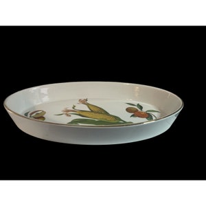 May include: White oval ceramic baking dish with a gold rim. The dish features a colorful illustration of corn on the cob and peaches.