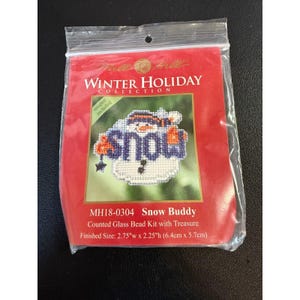 May include: A counted glass bead kit with treasure to create a snowman ornament. The ornament is 2.75 inches wide by 2.25 inches high. The kit includes a magnet. The snowman is holding a sign that says "snow".