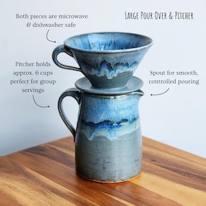 May include: A large, handmade pour-over coffee set with a matching pitcher. The set is glazed in shades of blue and gray. The pitcher holds approximately 6 cups. The pour-over has a spout for controlled pouring. Both pieces are microwave and dishwasher safe.