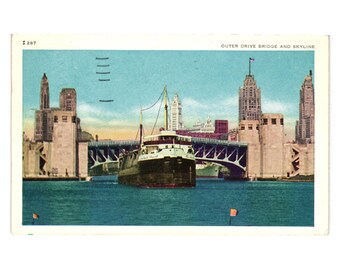 May include: Vintage postcard depicting a harbour scene with a large ship sailing under a bridge. The postcard shows a city skyline with tall buildings and the text "Outer Drive Bridge and Skyline". The water is a deep blue.