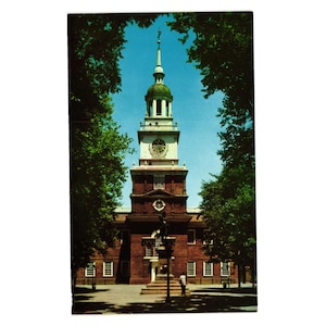 May include: A red brick building with a tall, white clock tower. The tower has a green dome and a clock face. The building is surrounded by trees.