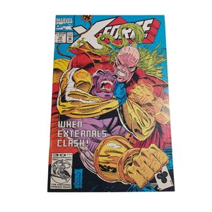 May include: A comic book cover featuring a yellow, red, and blue X-Force logo. The cover art depicts two characters in a fight, one with a purple body and the other with a red and yellow body. The text on the cover reads "When Externals Clash!" and "30th Anniversary 1962-1992".