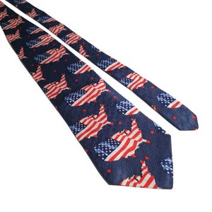 May include: A navy blue necktie featuring a repeating pattern of the United States map filled with the American flag design of red and white stripes and a blue field with white stars, accented by small red stars scattered across the dark blue background.
