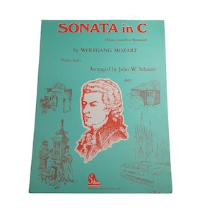 May include: A vintage sheet music cover for a piano solo of Mozart's Sonata in C, arranged by John W. Schaum. The cover features a portrait of Mozart and a price of 60 pence.