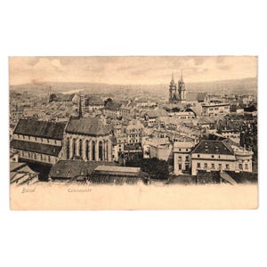 May include: Vintage postcard featuring a sepia-toned cityscape of Basel, Switzerland. The image showcases a dense urban landscape with numerous buildings, including churches and residential structures. The text "Basel" and "Catalansicht" are visible.