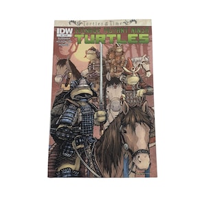 May include: A comic book cover featuring the Teenage Mutant Ninja Turtles as samurai warriors riding horses. The cover has the text "IDW Teenage Mutant Ninja Turtles" and "Turtles in Time". The artwork is detailed with a forest background.