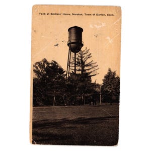 May include: Vintage postcard featuring a water tower at Soldiers' Home in Noroton, Connecticut. The sepia-toned image shows the tower atop a tall structure, surrounded by trees and a grassy field. Text at the top reads "Tank at Soldiers' Home, Noroton, Town of Darien, Conn."