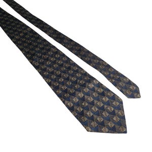 Puede incluir: Una corbata azul oscuro con un patrón geométrico de cuadrados dorados y azules.
