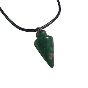 May include: A green and red gemstone pendulum pendant on a black cord. The pendulum has a conical shape with a rounded top and is suspended from a silver-colored bail. The cord is knotted and appears to be made of a woven material.