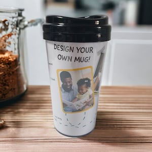 May include: White travel mug with a black lid. The mug has a design that says "Design your own mug!" and features a photo of a father and daughter reading a book together.