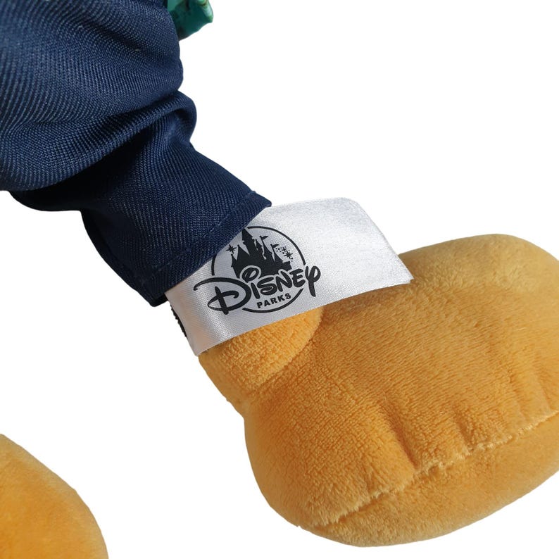 May include: A plush toy with a blue and green outfit and a white tag that says "Disney Parks".