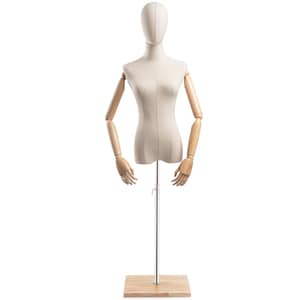 Op de afbeelding: Een beige stoffen paspop met beweegbare houten armen en handen. De torso is gemonteerd op een chromen paal en een lichte houten basis. De kop is bedekt met bijpassende beige stof.