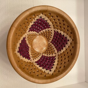May include: A wooden bowl with a geometric pattern of squares and rectangles in shades of brown and burgundy.