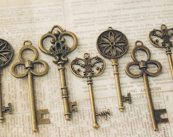 May include: A collection of six antique-style keys with ornate designs. The keys are made of metal and have a bronze finish. They are arranged on a piece of paper with text.