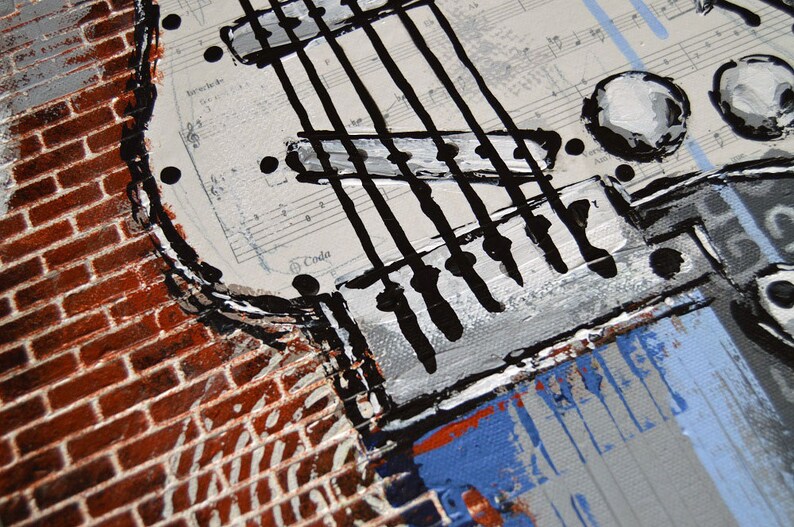 K&ouml;nnte beinhalten: Nahaufnahme eines Gitarren-Kunstwerks. Das Gem&auml;lde zeigt einen Gitarrenkorpus mit schwarzen Saiten, wei&szlig;en Stimmwirbeln und einem Hintergrund aus Notenbl&auml;ttern. Eine Backsteinmauer und blaue Akzente setzen Kontraste.
