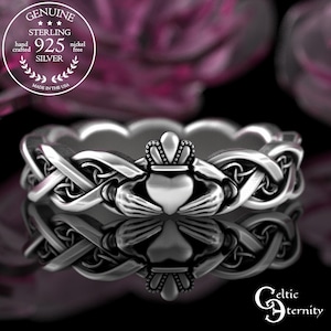May include: A sterling silver Claddagh ring with a heart, crown, and hands design. The ring features intricate Celtic knotwork and the text "GENUINE STERLING 925 SILVER" in a circular emblem. The ring is nickel free and made in the USA.