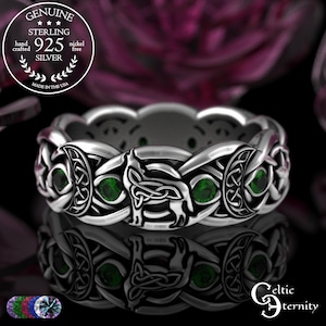 May include: A sterling silver ring with a Celtic knot design, featuring green gemstones. The ring is hand-crafted and nickel-free, with the text "GENUINE STERLING 925 SILVER" and "MADE IN THE USA". The ring has a wolf and moon design.