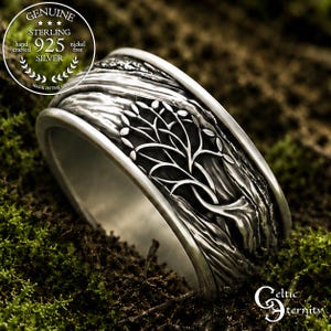 May include: A sterling silver ring featuring an embossed tree design with a dark oxidized finish. The band includes text reading GENUINE STERLING 925 NICKEL FREE HAND CRAFTED MADE IN THE USA and the brand name Celtic Eternity in the corner.