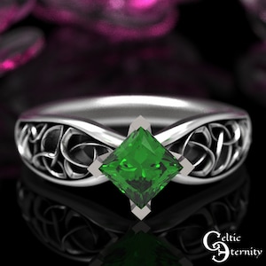 Puede incluir: Un anillo de plata con un nudo celta y una piedra preciosa cuadrada verde esmeralda en el centro.