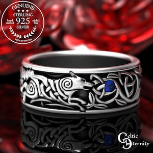 May include: A sterling silver ring with a Celtic design featuring a wolf and blue accents. The ring is nickel-free and hand-crafted in the USA. The ring has the text "GENUINE STERLING 925 SILVER" and "MADE IN THE USA".
