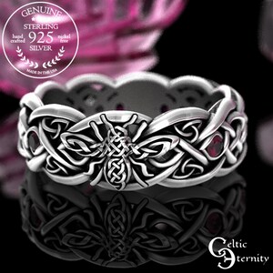 May include: A sterling silver ring featuring a central bee motif integrated into an intricate Celtic knotwork band. The design includes small, round, deep red gemstones set within the silver pattern. Text on the image reads: GENUINE STERLING 925 SILVER hand crafted nickel free MADE IN THE USA and Celtic eternity.