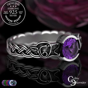 May include: A sterling silver ring with a Celtic wolf design and a round, purple gemstone. The ring is hand-crafted and nickel-free. The text on the ring says "Genuine Sterling 925 Silver" and "Made in the USA".
