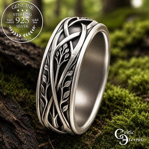 May include: A sterling silver ring featuring an intricate, raised vine and leaf pattern against a darkened, recessed background. The band has a polished silver edge and a smooth interior surface. The metal is marked as 925 sterling silver.