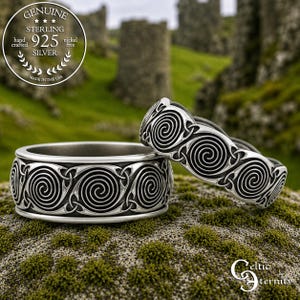 Könnte beinhalten: Zwei Ringe aus Sterlingsilber mit einem durchgehenden geprägten Spiralmuster und dunkel oxidierten vertieften Bereichen. Die Ringe sind aus 925er Silber gefertigt und nickelfrei. Ein kreisförmiges Siegel oben links zeigt den Text Genuine Sterling 925 Silver Hand Crafted Nickel Free Made in the USA.