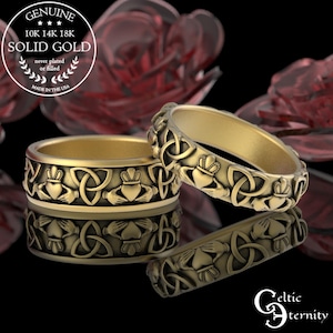 Op de afbeelding: Goudkleurige ringen met Keltische knoop- en Claddagh-ontwerpen. De ringen worden getoond op een reflecterend oppervlak, met de tekst "GENUINE 10K 14K 18K SOLID GOLD" en "MADE IN THE USA". De ringen zijn van "Celtic Eternity".