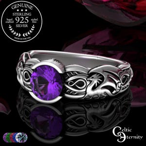 May include: A sterling silver ring with a large, round, faceted purple gemstone. The ring features a dragon design on the band and is marked "Genuine Sterling 925 Silver". The ring is nickel free and hand crafted in the USA.