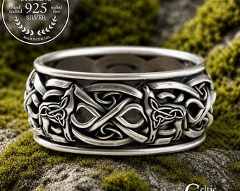 May include: A sterling silver ring featuring an intricate relief pattern of wolves intertwined with Celtic knotwork. The band has a polished finish with darkened recessed areas to highlight the detailed metalwork and wolf motifs.