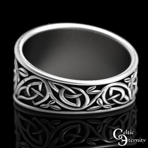 Pu&ograve; includere: Anello in argento con nodo celtico, decorato con un designo dettagliato di nodi e foglie intrecciati. L'anello &egrave; largo e ha una finitura lucida.