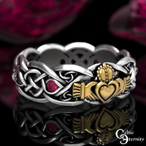 May include: A silver Celtic knot ring with a gold Claddagh design featuring a heart, hands, and crown. The ring is set with three red gemstones.