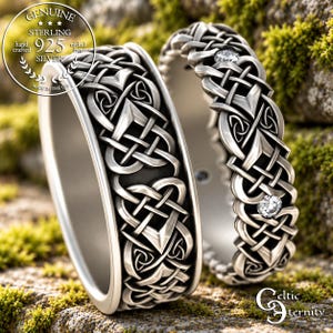 Könnte beinhalten: Zwei Ringe aus Sterlingsilber mit komplizierten, ineinander verschlungenen Knotenmustern. Der breitere Ring hat eine glatte Innenseite, während der schmalere Ring mit zwei kleinen, klaren, rund geschliffenen Steinen im Metall verziert ist.